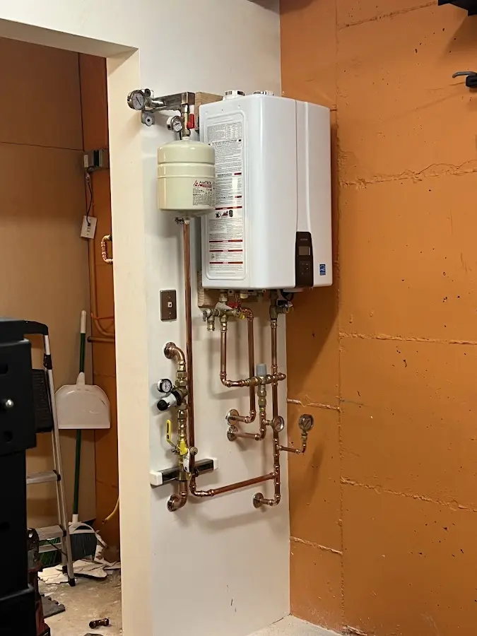 Plumbing technician inspecting water heater connections in Amory